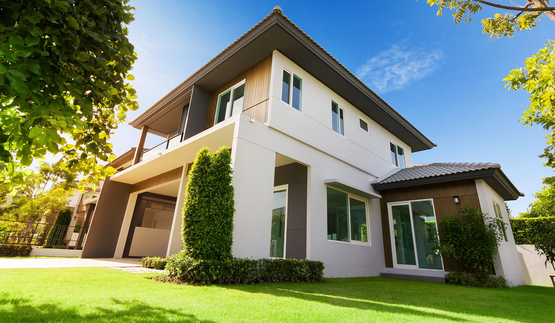 Modernes Wohngebäude auf einer großzügigen Rasenfläche, umgeben von Bäumen